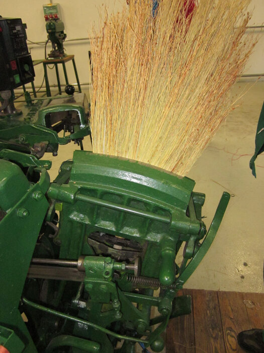 Broom making with a machine.