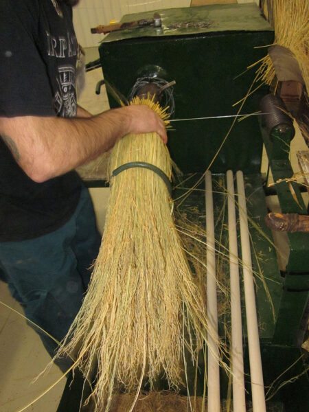 A worker is making a broom.
